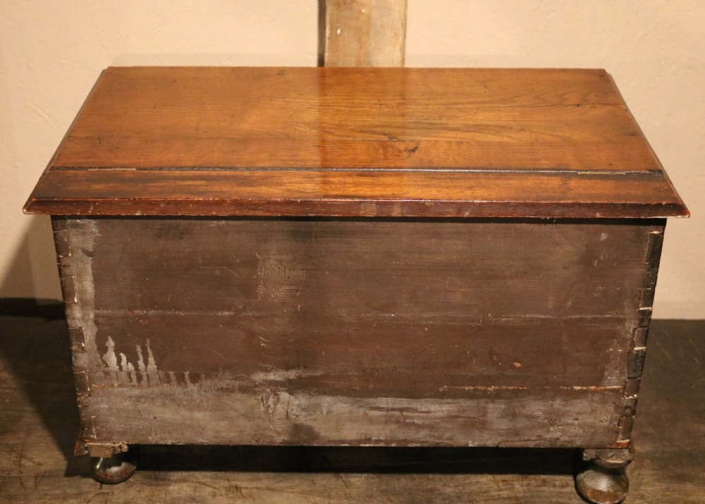 An 18th-century Welsh oak coffer bach featuring geometric inlay, a single lower drawer with brass handles, and turned bun feet. View IX