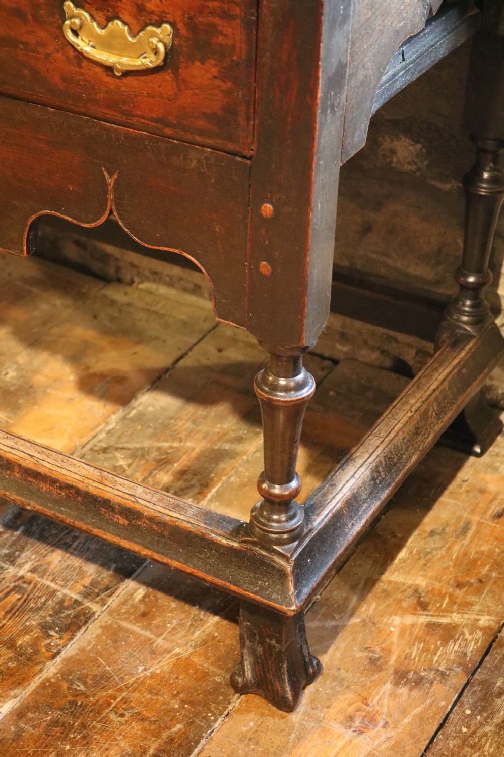 An 18th-century Welsh dark oak side table with a single drawer, brass handles, a scalloped apron, turned legs, and stretchers. View VI