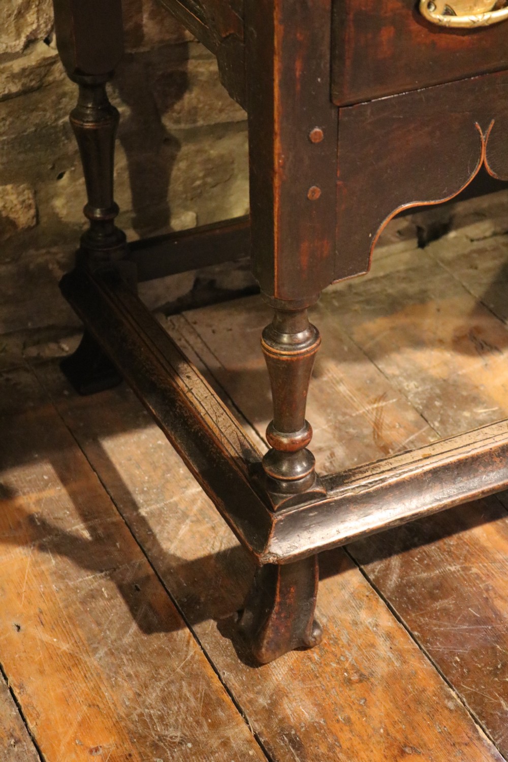 An 18th-century Welsh dark oak side table with a single drawer, brass handles, a scalloped apron, turned legs, and stretchers. View VII