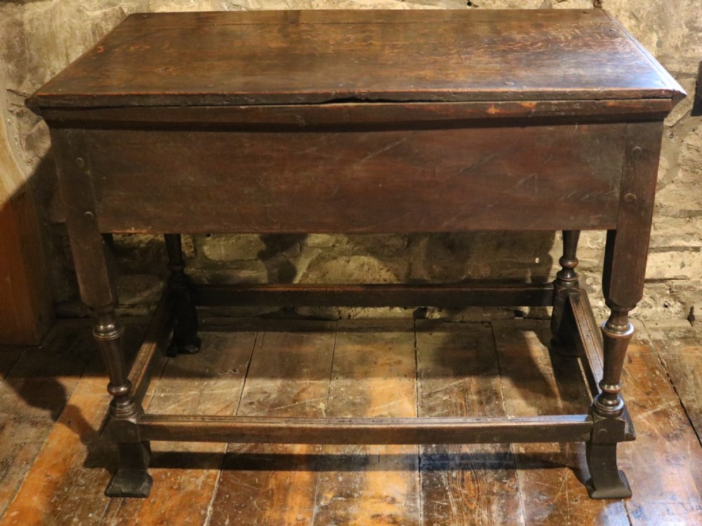 An 18th-century Welsh dark oak side table with a single drawer, brass handles, a scalloped apron, turned legs, and stretchers. View XIII