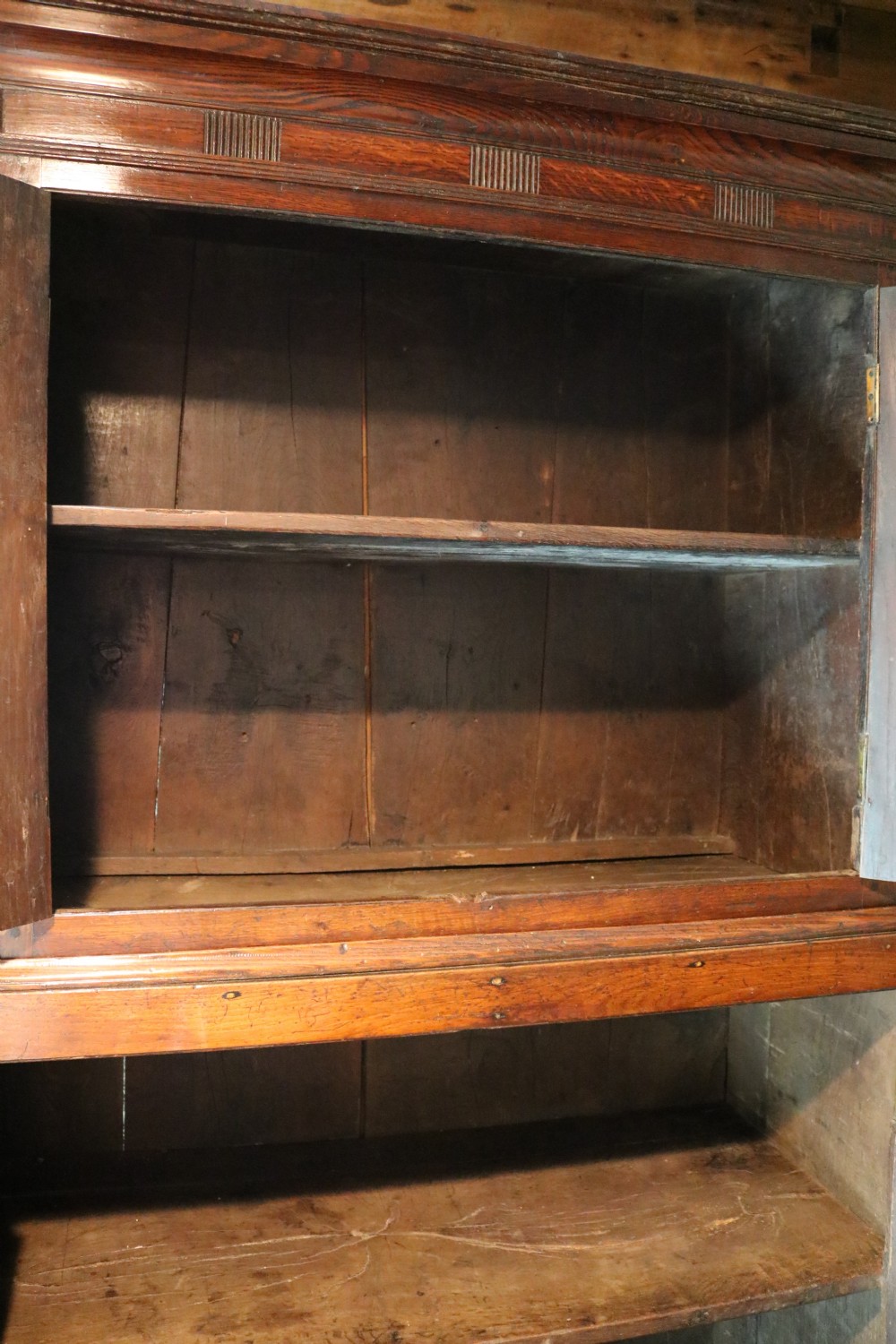An 18th-century dark Welsh oak press cupboard featuring double doors with ogee arched fielded panels on top and rectangular fielded panels below. View VI