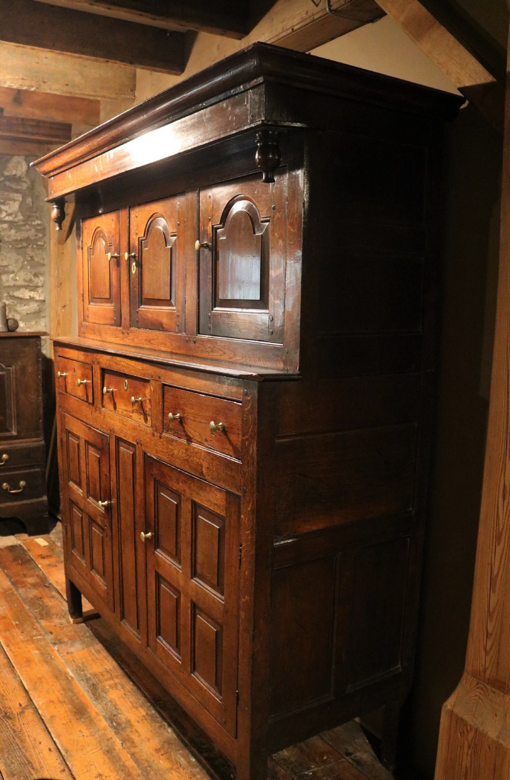 An eighteenth-century Welsh oak deuddarn two-part cupboard featuring a moulded cornice, three upper panelled doors with ogee arches, three mid drawers, and a lower cabinet with field panelled doors. View III
