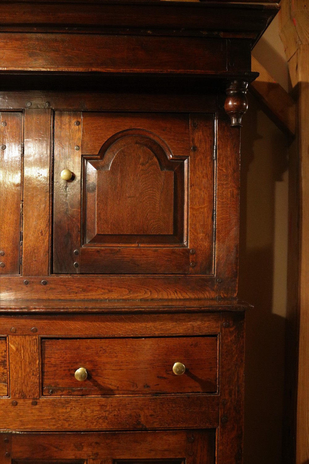 An eighteenth-century Welsh oak deuddarn two-part cupboard featuring a moulded cornice, three upper panelled doors with ogee arches, three mid drawers, and a lower cabinet with field panelled doors. View VI