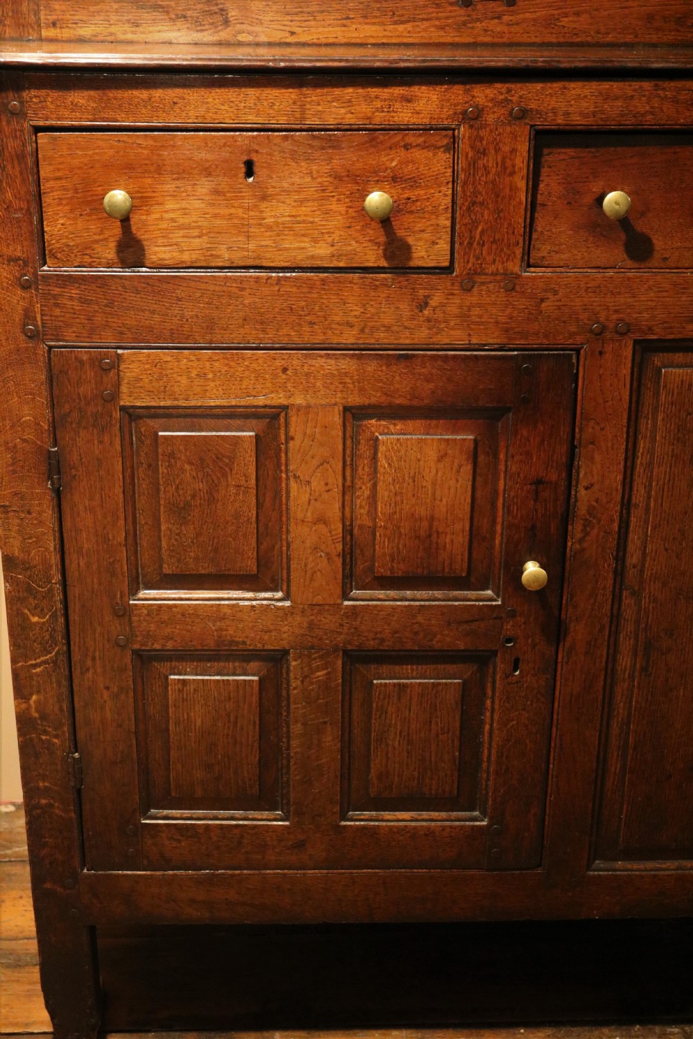 An eighteenth-century Welsh oak deuddarn two-part cupboard featuring a moulded cornice, three upper panelled doors with ogee arches, three mid drawers, and a lower cabinet with field panelled doors. View VII