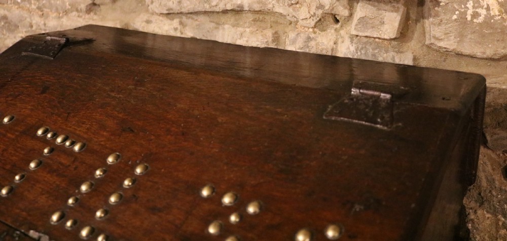 A dark oak sloped desk box featuring brass stud detailing with the year 1732, carved letters T M, and an iron lock plate. View V