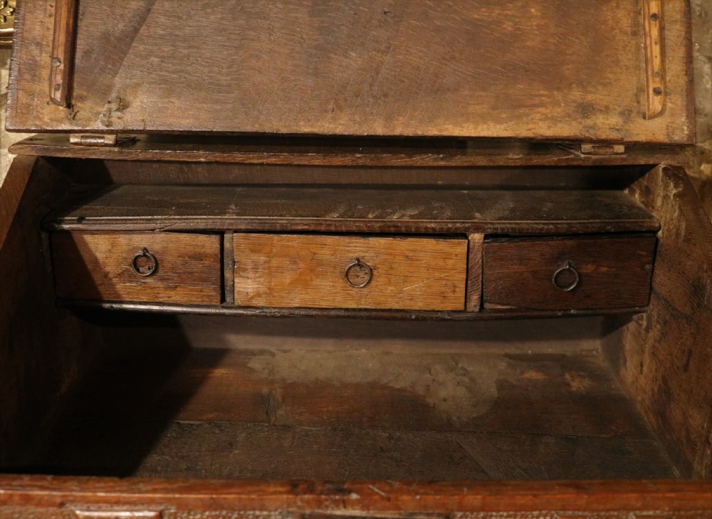 A dark oak sloped desk box featuring brass stud detailing with the year 1732, carved letters T M, and an iron lock plate. View VI