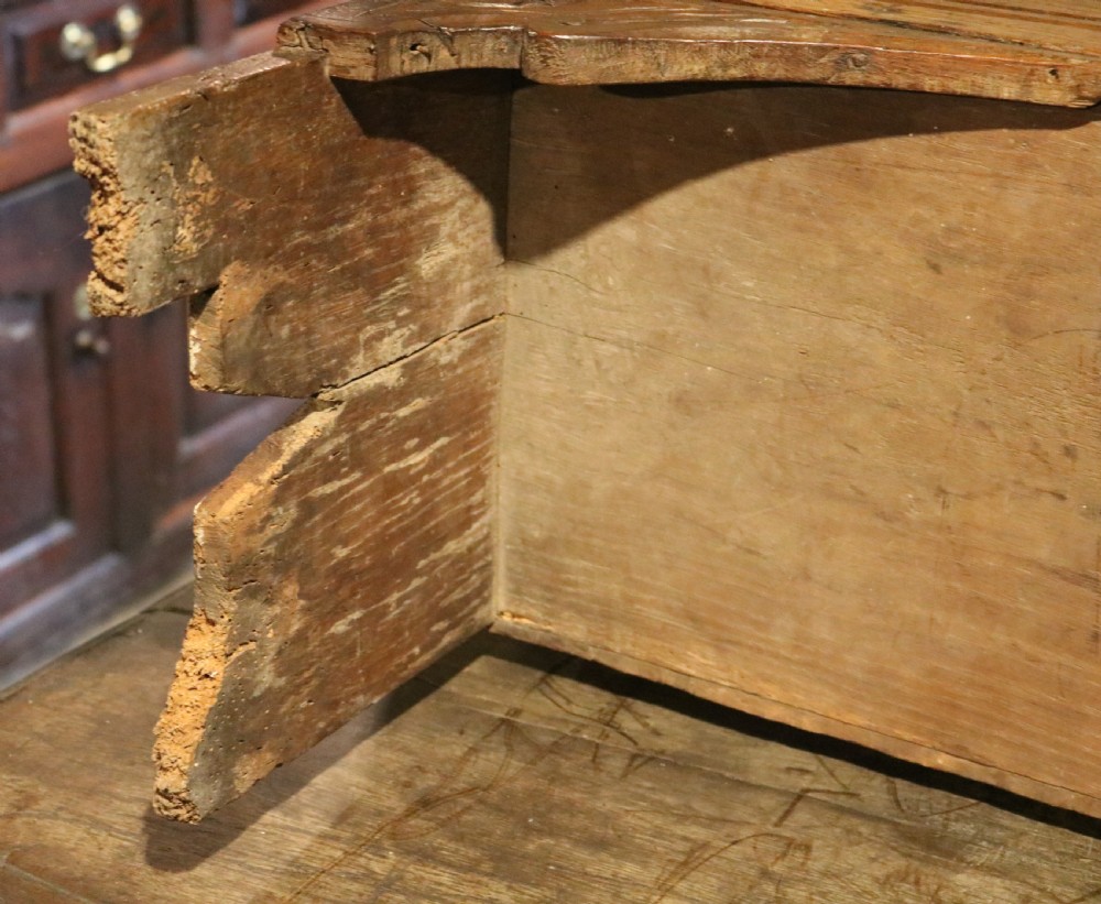 A dark brown carved oak chest featuring relief carvings of dragons, floral rosettes, and a central iron lock plate. View VII