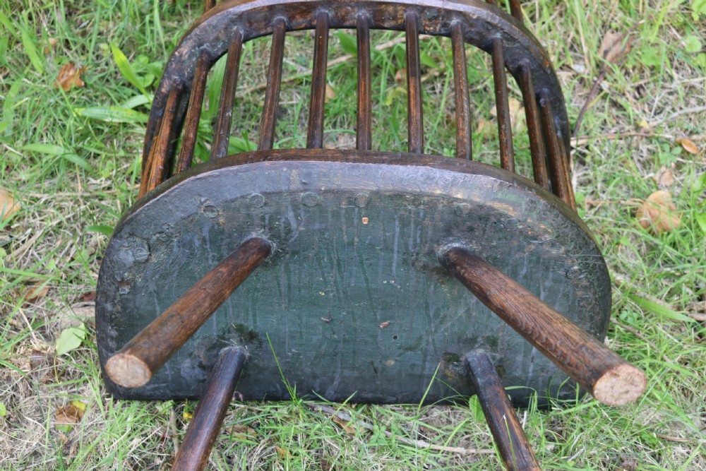 An eighteenth-century Welsh stick chair crafted from dark patinated wood featuring a comb back, curved armrests, and splayed turned legs. View VI