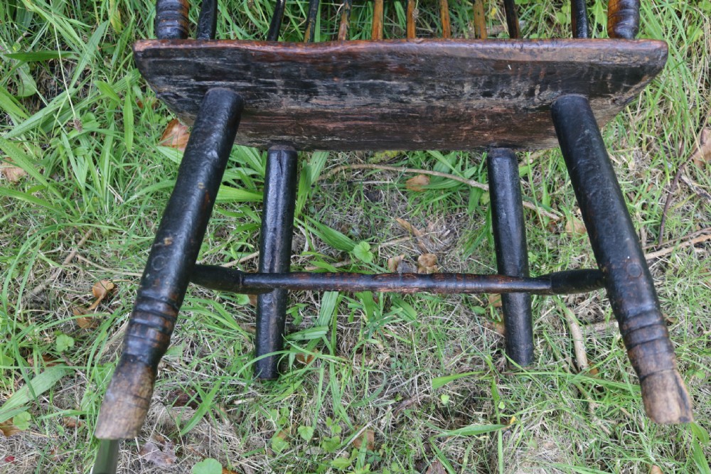 An eighteenth-century Welsh stick chair crafted from dark patinated wood featuring a comb back, curved armrests, and splayed turned legs. View IX