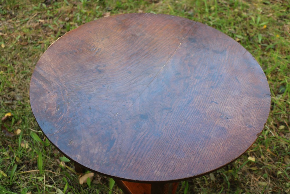 A Georgian three-legged oak cricket table featuring a circular top and a lower triangular stretcher shelf. View V