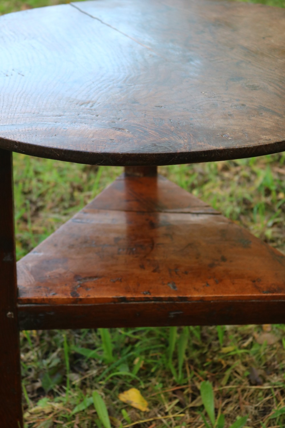 A Georgian three-legged oak cricket table featuring a circular top and a lower triangular stretcher shelf. View VII