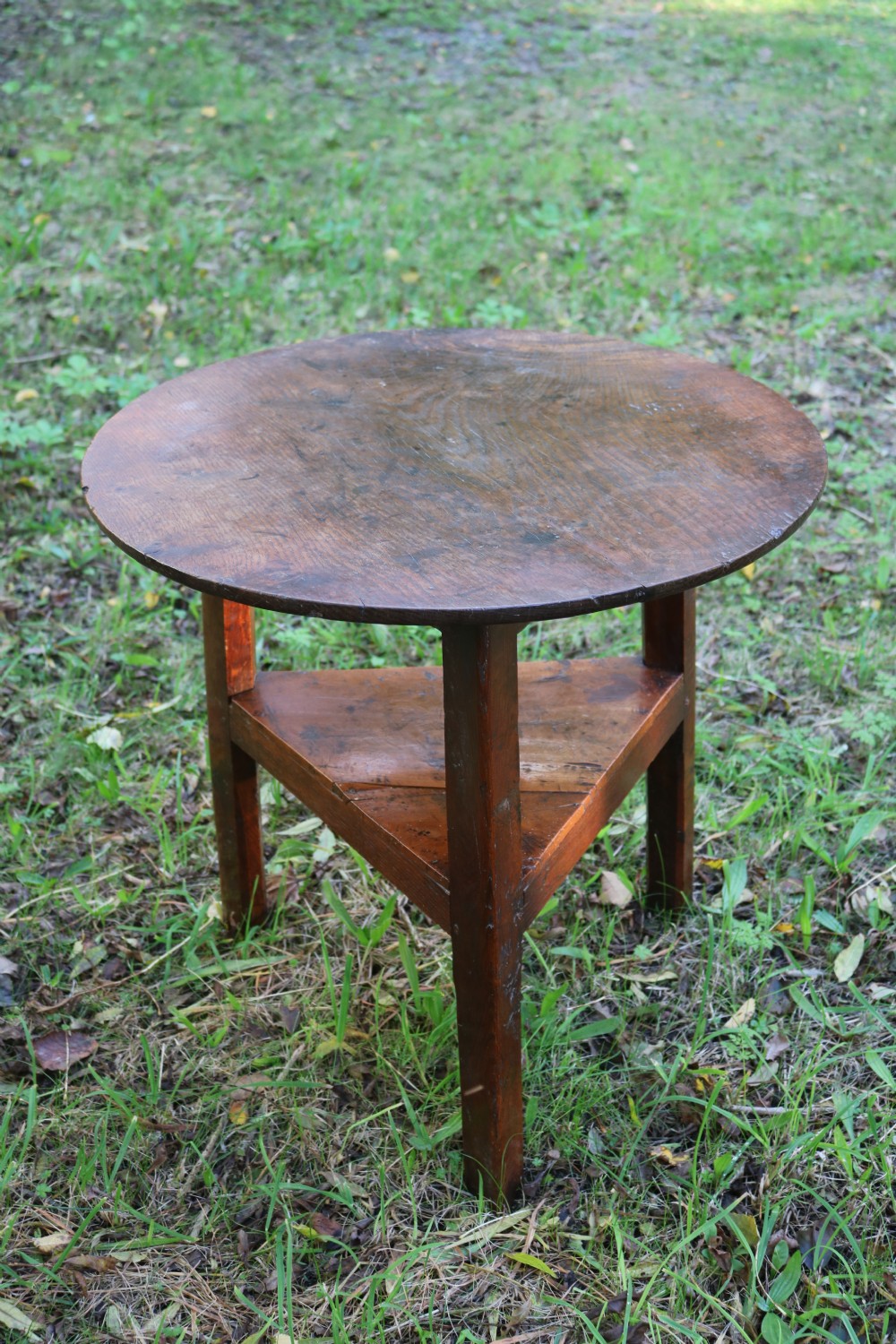 A Georgian three-legged oak cricket table featuring a circular top and a lower triangular stretcher shelf. View XII
