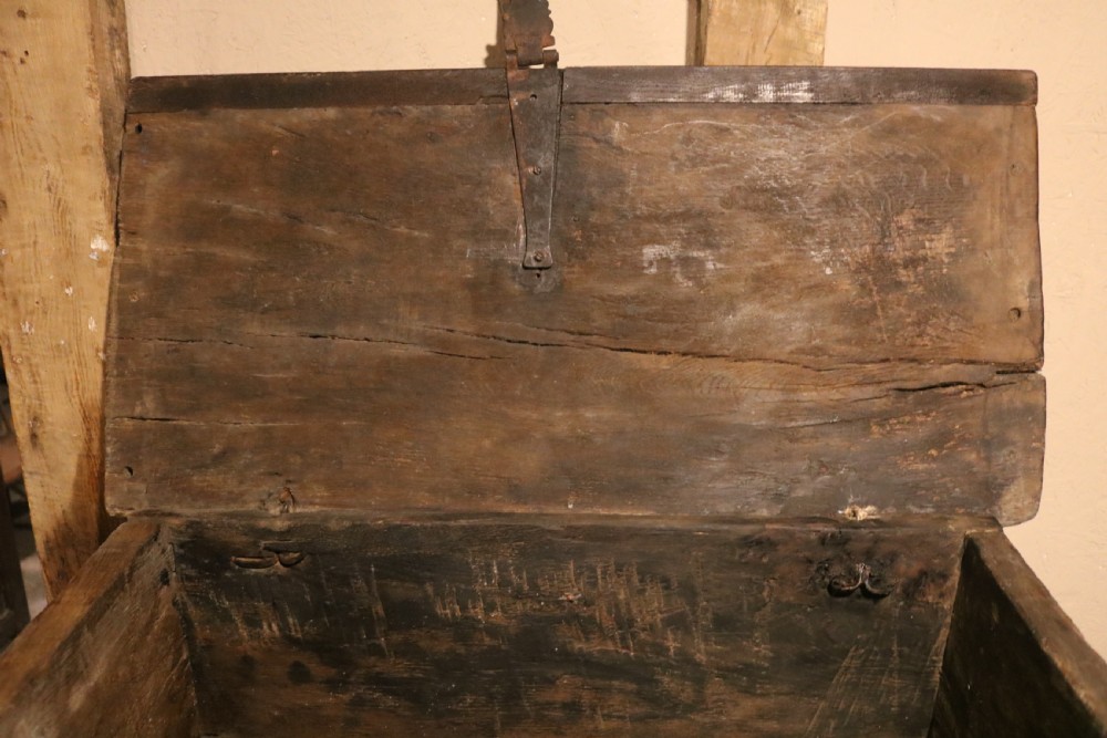 An antique dark brown chestnut wood deed box featuring carved Gothic arch panels and a hand-forged iron lock plate on the front. View X