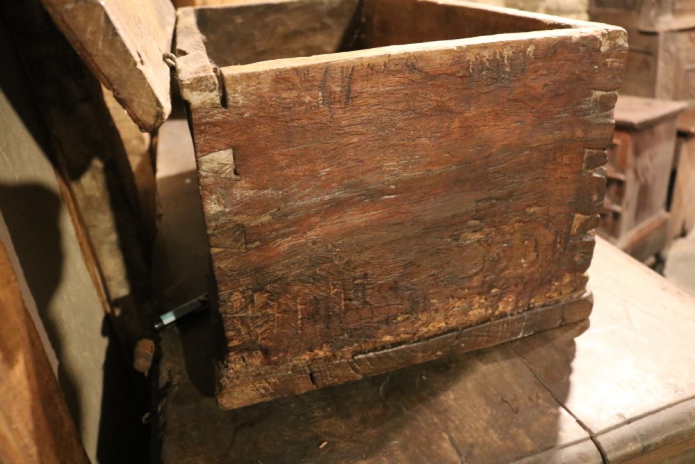 An antique dark brown chestnut wood deed box featuring carved Gothic arch panels and a hand-forged iron lock plate on the front. View XIV