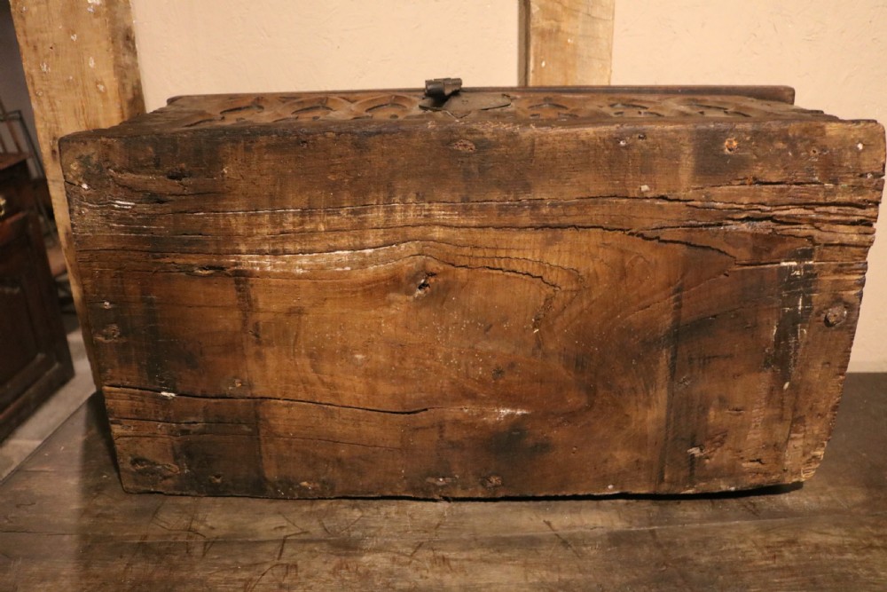 An antique dark brown chestnut wood deed box featuring carved Gothic arch panels and a hand-forged iron lock plate on the front. View XVI