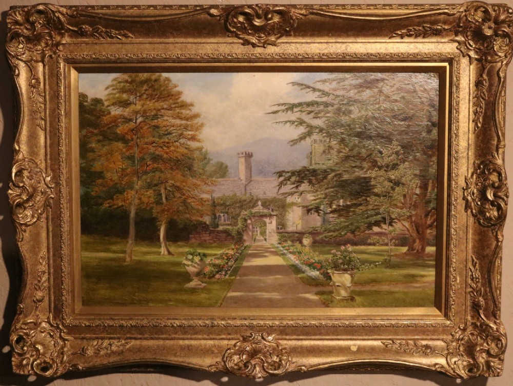 A 19th-century landscape oil painting depicting a formal garden pathway leading towards a stone manor house, enclosed within an ornate gold giltwood frame.