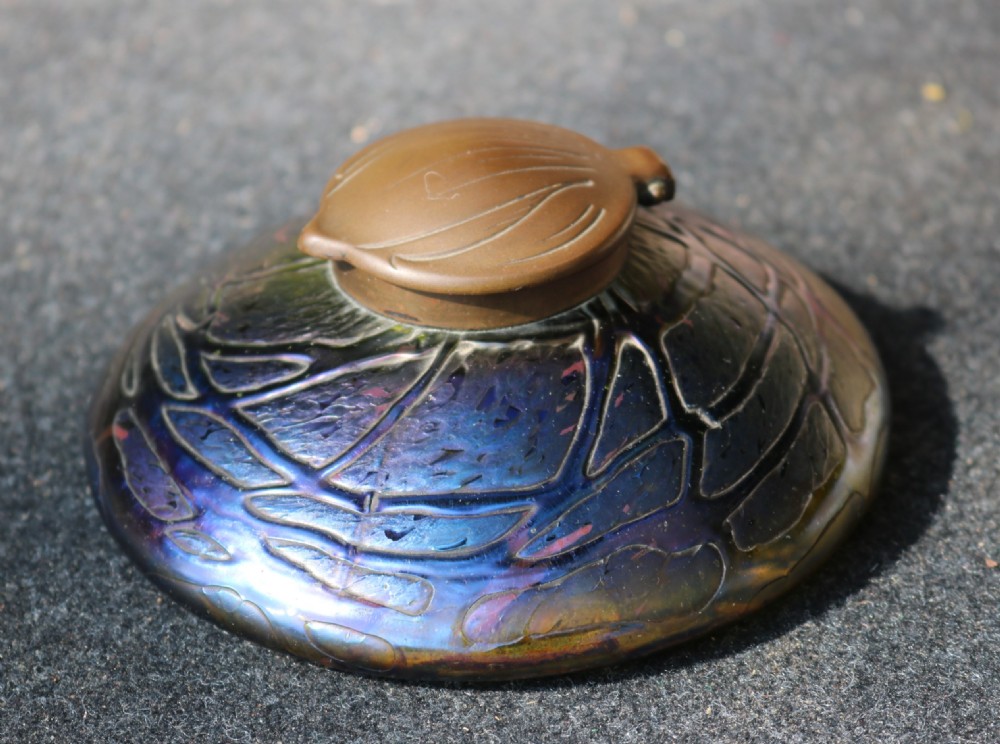 A low domed Art Nouveau iridescent blue glass inkwell with raised veined patterns and a hinged brass lid. View X