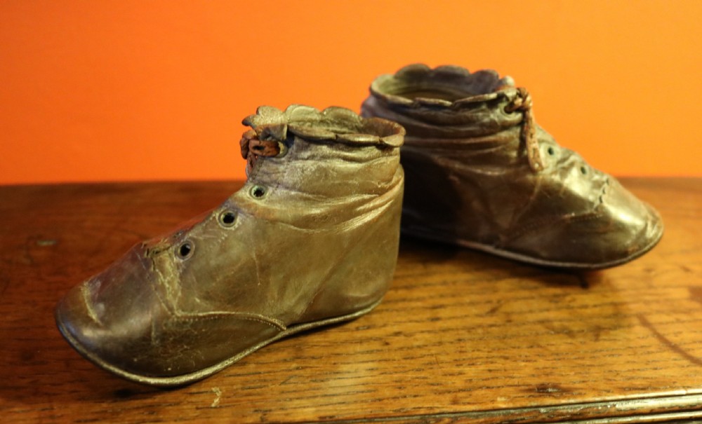A pair of aged dark brown leather Victorian childrens ankle boots featuring laced fronts with metal eyelets. View II