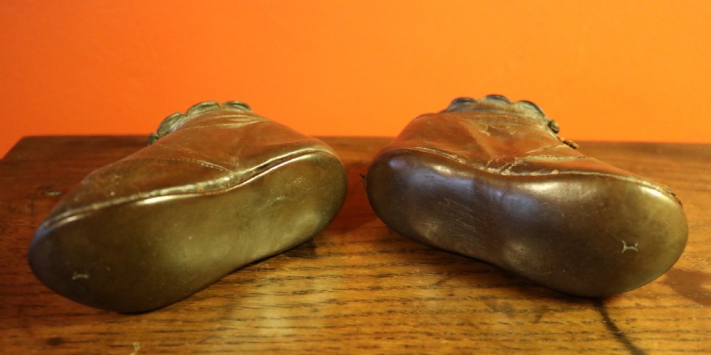 A pair of aged dark brown leather Victorian childrens ankle boots featuring laced fronts with metal eyelets. View III