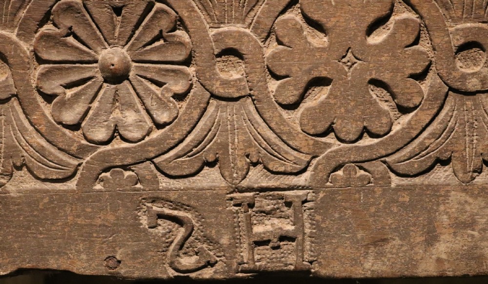 A 16th-century Tudor carved oak coffer featuring a carved rosette frieze, central wrought iron lockplate, and slab end supports. View II
