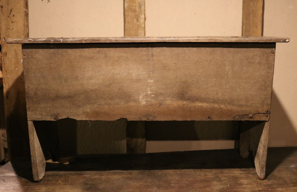 A 16th-century Tudor carved oak coffer featuring a carved rosette frieze, central wrought iron lockplate, and slab end supports. View VI