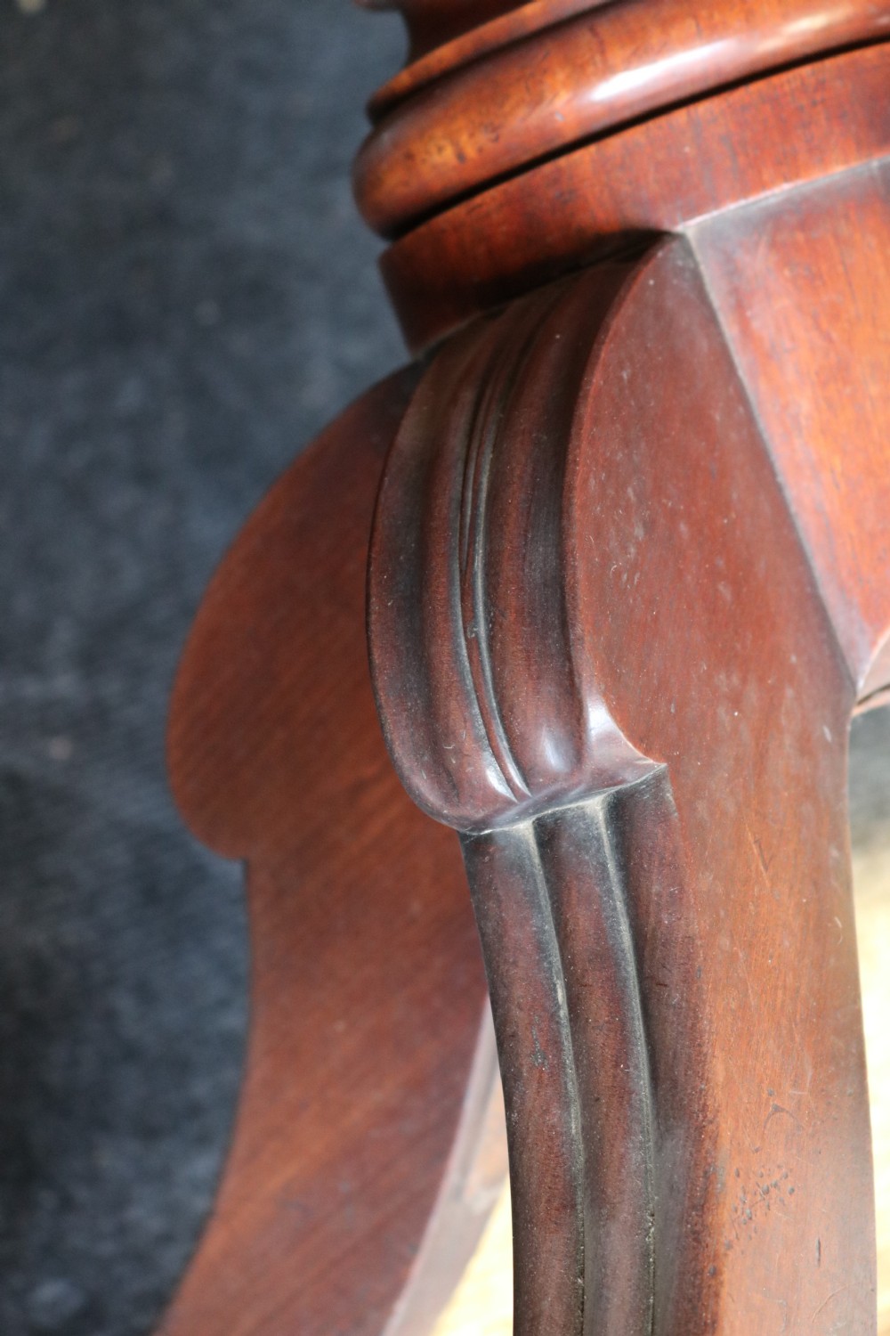A Regency mahogany dining table featuring a rectangular drop-leaf top supported by a central reeded pedestal and four splayed legs with brass toe castors. View XIV