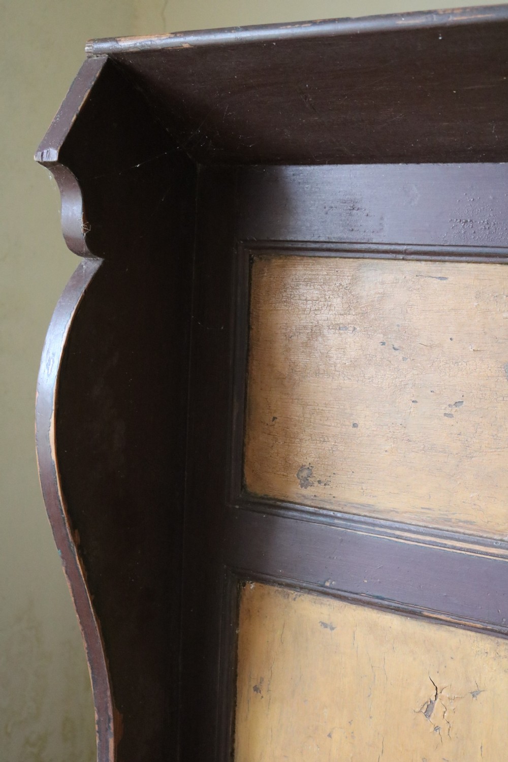 A high-backed Welsh pine settle bench featuring a two-tone dark brown and ochre painted finish with raised panel detailing and shaped wing sides. View VI