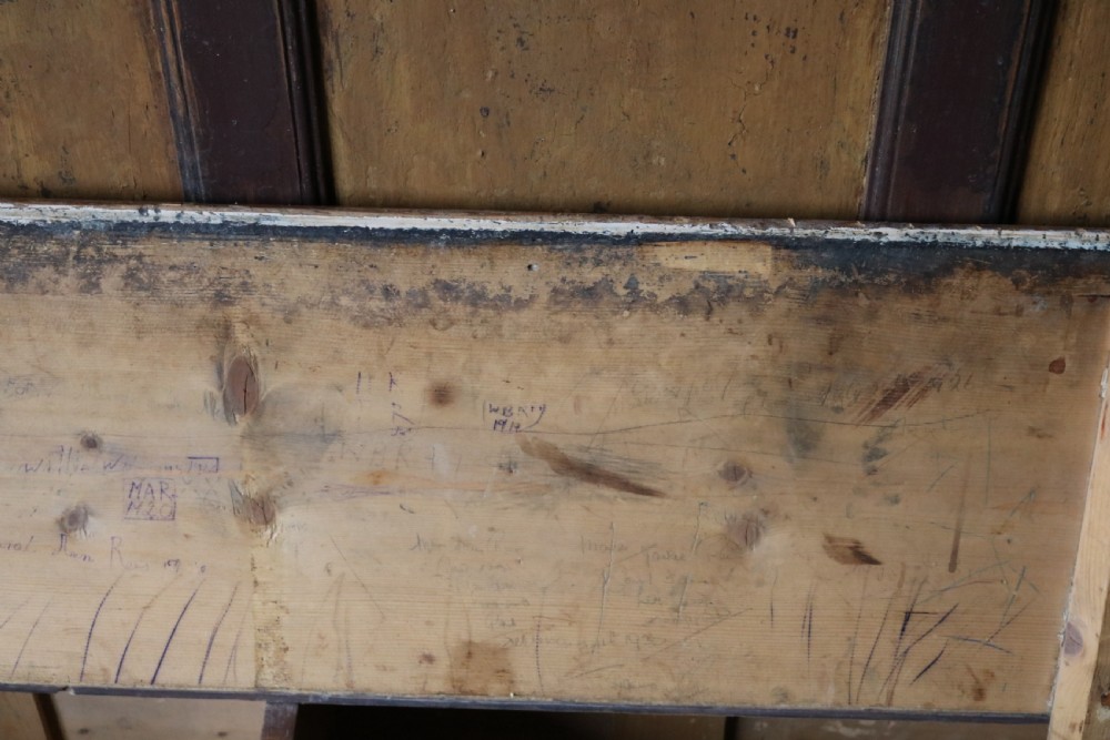 A high-backed Welsh pine settle bench featuring a two-tone dark brown and ochre painted finish with raised panel detailing and shaped wing sides. View XIV
