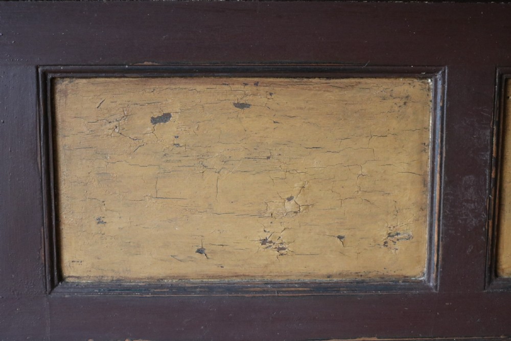 A high-backed Welsh pine settle bench featuring a two-tone dark brown and ochre painted finish with raised panel detailing and shaped wing sides. View XIX