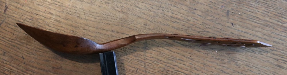 A hand-carved Welsh fruitwood lovespoon featuring an intricate fretwork handle with botanical cut-out motifs and a smooth oval bowl. View III