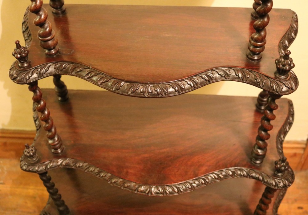 A five-tiered Regency rosewood whatnot with barley twist support columns, carved serpentine edges, and top finials. View VI
