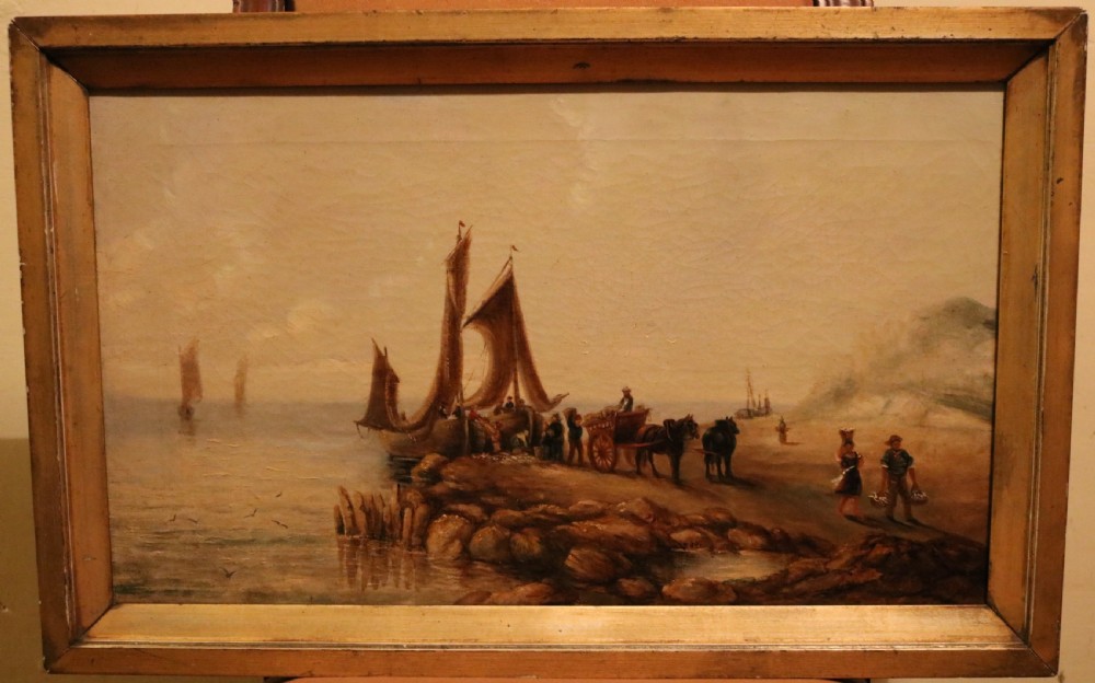 Victorian oil painting depicting a coastal marine scene with fishing boats and figures, housed within a simple wooden frame.