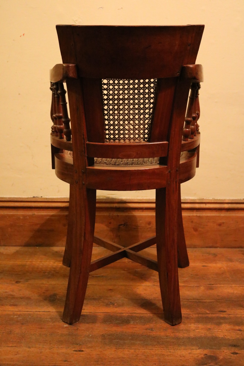 A Victorian mahogany parlour chair featuring a woven cane seat, curved backrest, and turned spindle armrests. View V