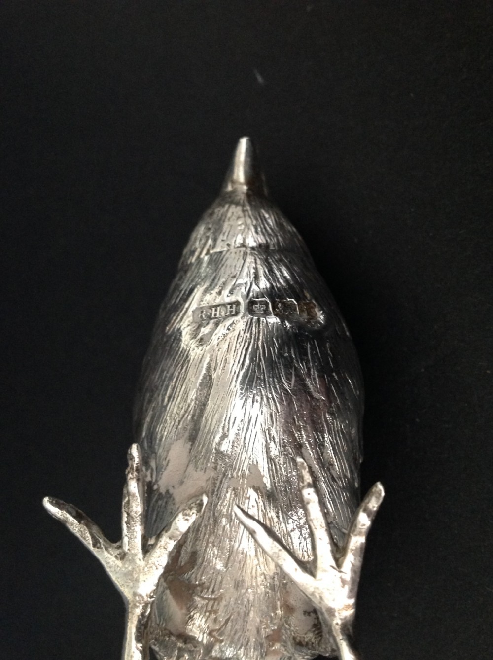 A cast silver pepper pot fashioned in the detailed form of a standing bird with pierced holes on its head. View V
