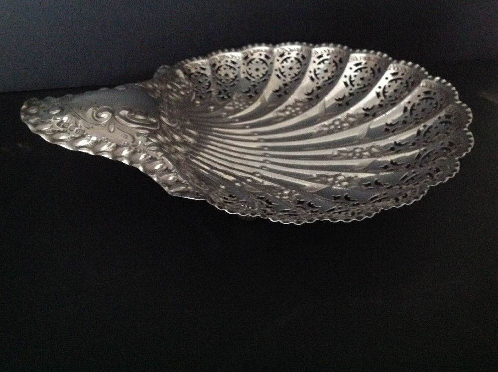 A late Victorian silver dish shaped like a scallop shell featuring detailed pierced scrollwork and fluted ridges. View II