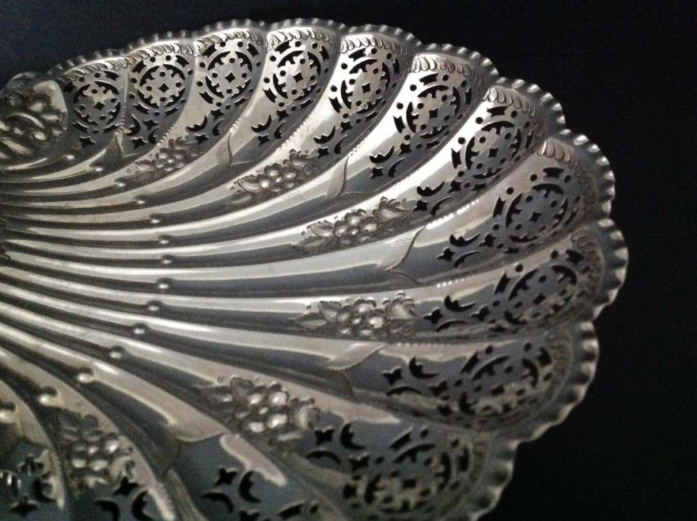 A late Victorian silver dish shaped like a scallop shell featuring detailed pierced scrollwork and fluted ridges. View V