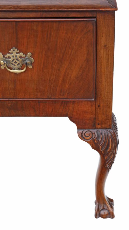 fig 1. A Georgian figured walnut chest of drawers featuring ornate brass handles and escutcheons, set on cabriole legs with carved claw and ball feet.