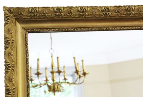 fig 1. A large rectangular antique gilt overmantel mirror featuring detailed moulded borders and a gold finish.