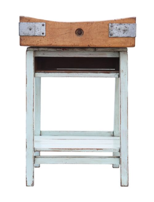 fig 2. A mid-twentieth-century wooden butchers block with a dished end-grain top, metal corner brackets, and a pale blue painted wooden stand with a lower shelf.