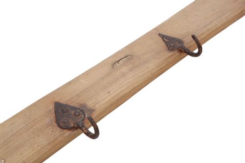 fig 2. A long horizontal pine timber rail fitted with nine spaced, hand-forged wrought iron hooks with pointed backplates.