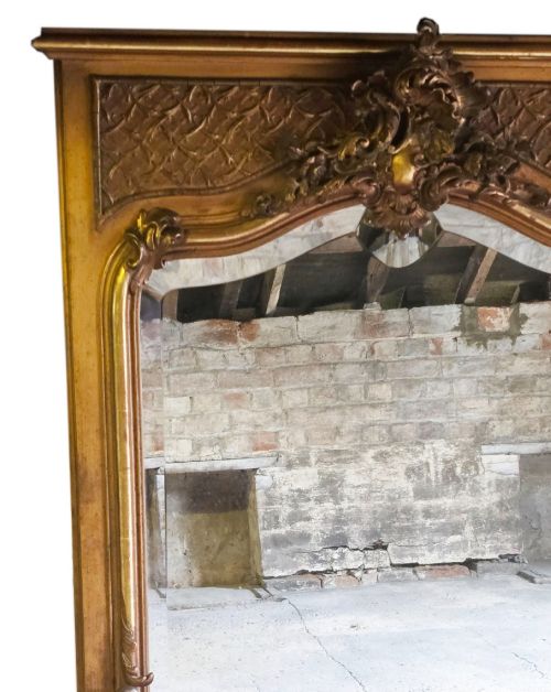 fig 1. A tall 19th-century gilded overmantel mirror featuring an arched frame, top cresting, and molded lattice frieze.