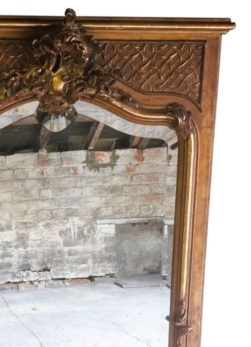 fig 2. A tall 19th-century gilded overmantel mirror featuring an arched frame, top cresting, and molded lattice frieze.
