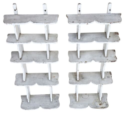 fig 3. A pair of 19th-century wall-mounted wooden shelves featuring five tiers with shaped, curved upright supports in a distressed white painted finish.