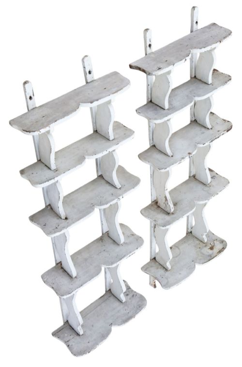 fig 4. A pair of 19th-century wall-mounted wooden shelves featuring five tiers with shaped, curved upright supports in a distressed white painted finish.