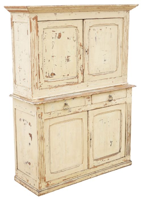 fig 1. A 19th-century two-tier wooden storage cupboard painted in distressed cream, featuring fluted side details, upper and lower double doors with fielded panels, and two central drawers.