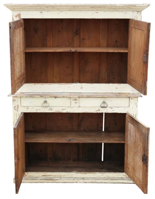 fig 3. A 19th-century two-tier wooden storage cupboard painted in distressed cream, featuring fluted side details, upper and lower double doors with fielded panels, and two central drawers.