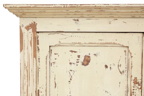 fig 6. A 19th-century two-tier wooden storage cupboard painted in distressed cream, featuring fluted side details, upper and lower double doors with fielded panels, and two central drawers.