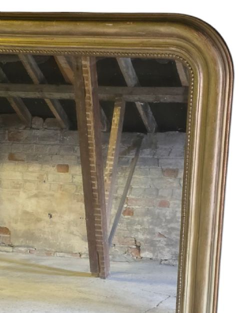 fig 2. A large rectangular gilt-framed wall mirror featuring rounded top corners and a beaded inner border.