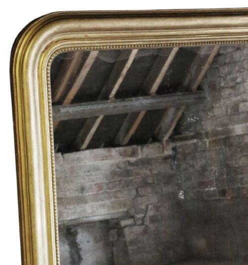 fig 3. A large rectangular gilt-framed wall mirror featuring rounded top corners and a beaded inner border.