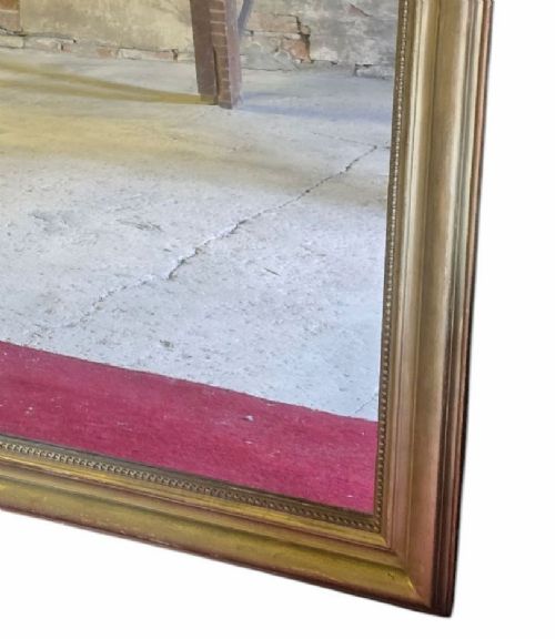 fig 6. A large rectangular gilt-framed wall mirror featuring rounded top corners and a beaded inner border.